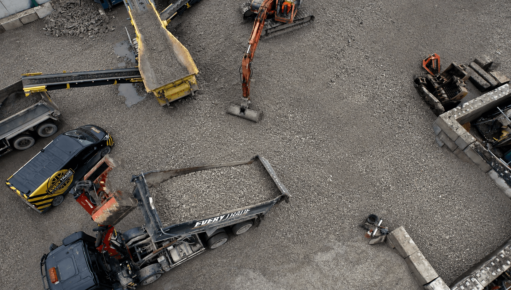 A picture from an aerial view of EveryTrade grabs trucks and vans collecting and unloading MOT Type 1 aggregates